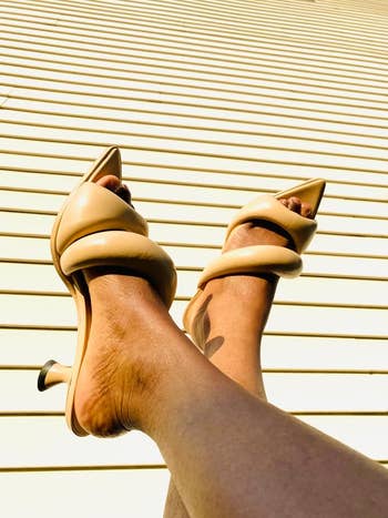 a reviewer showing a close up of the beige sandals
