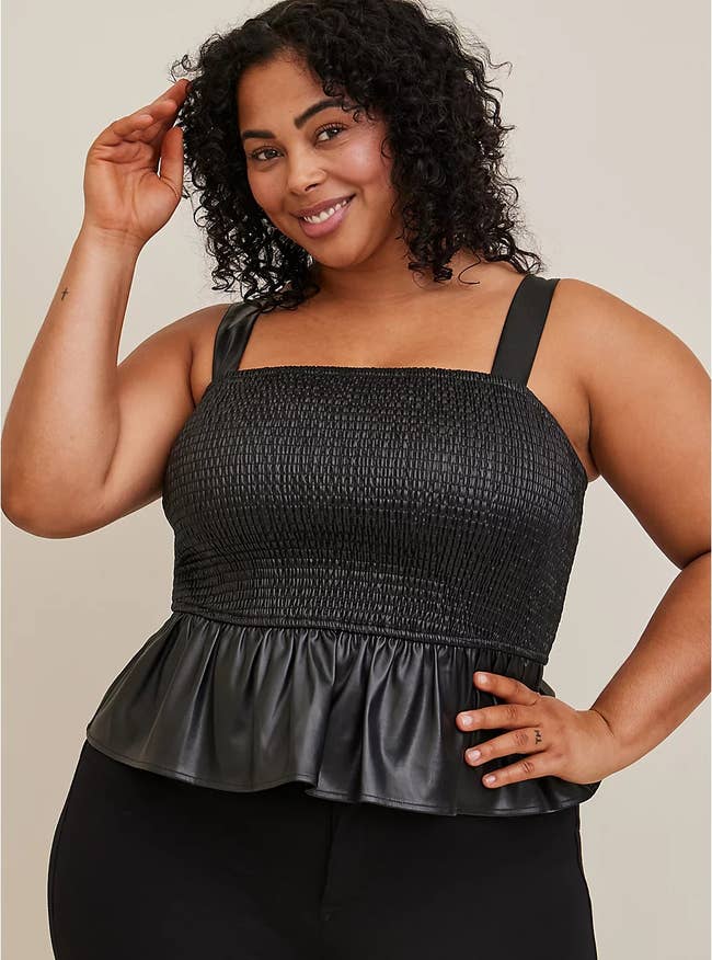 a plus size model wearing the faux leather peplum top
