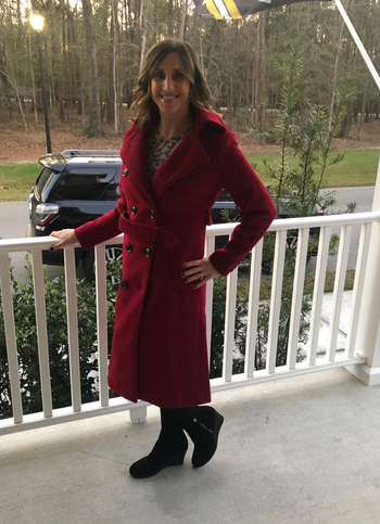 A reviewer wearing the coat in red