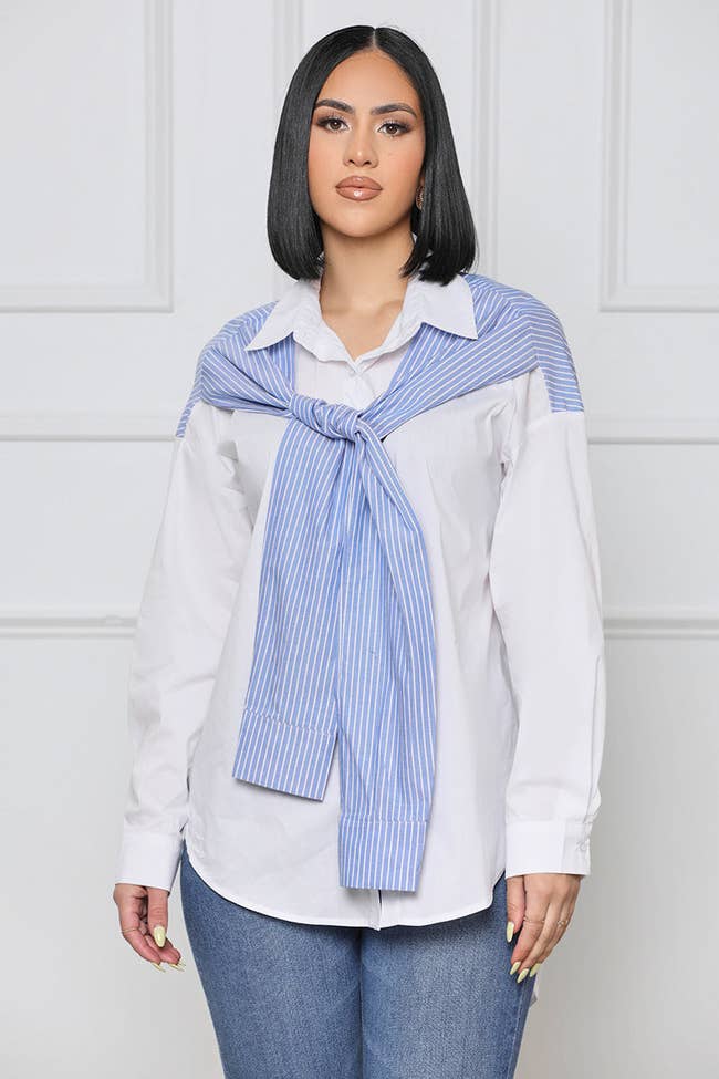 model in white button down with blue and white stripe panel that looks like sleeves knotted in front of the shirt