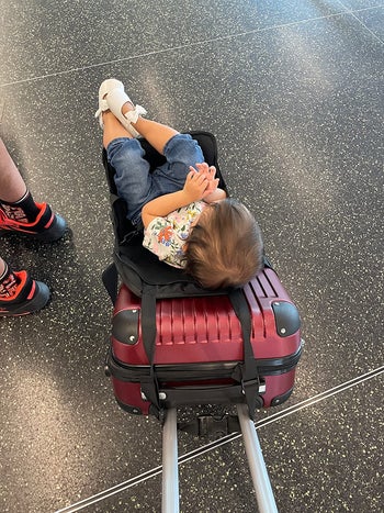 hotel customer picture of the seat connected to a carry-on luggage with a kid being in it
