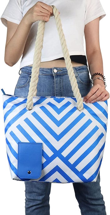 a model holding the blue and white stripped bag