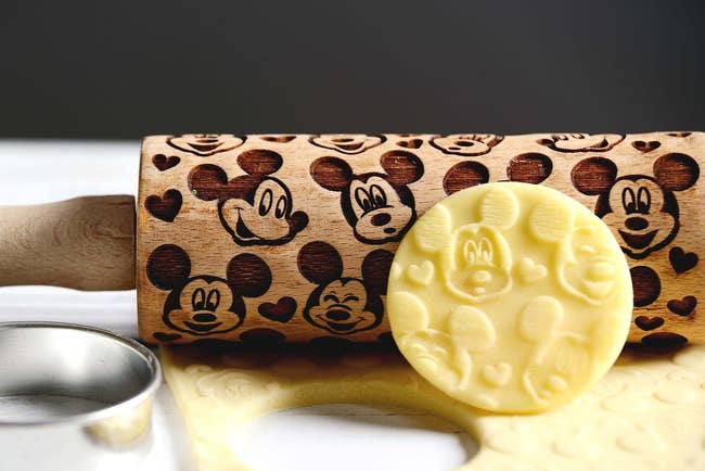 a mini rolling pin with mickey and hearts embossed on it