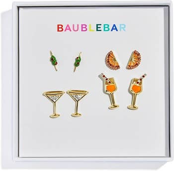  martini glasses, vino  glasses, olive picks, and citrus slices, branded by BaubleBar