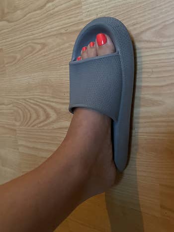 Foot wearing a textured descent sandal connected a woody floor