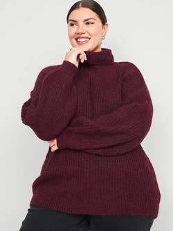 another model in a burgundy turtleneck sweater with the neck folded down