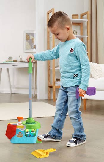 a child playing with the cleaning set