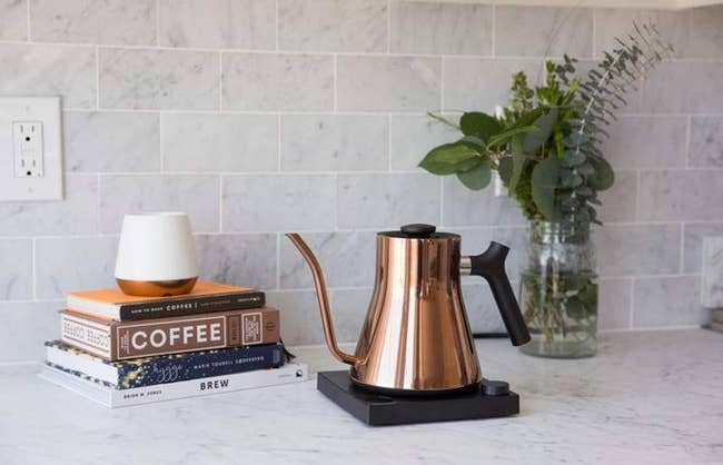 the polished copper electric kettle on its stand in a kitchen
