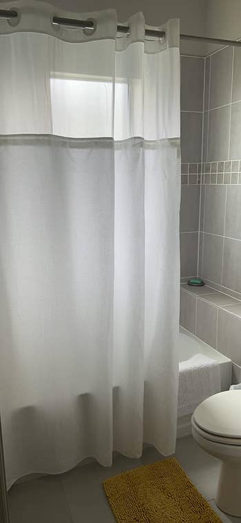 reviewer's white shower curtain with translucent panel 