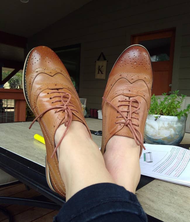 reviewer wearing brown oxford shoes