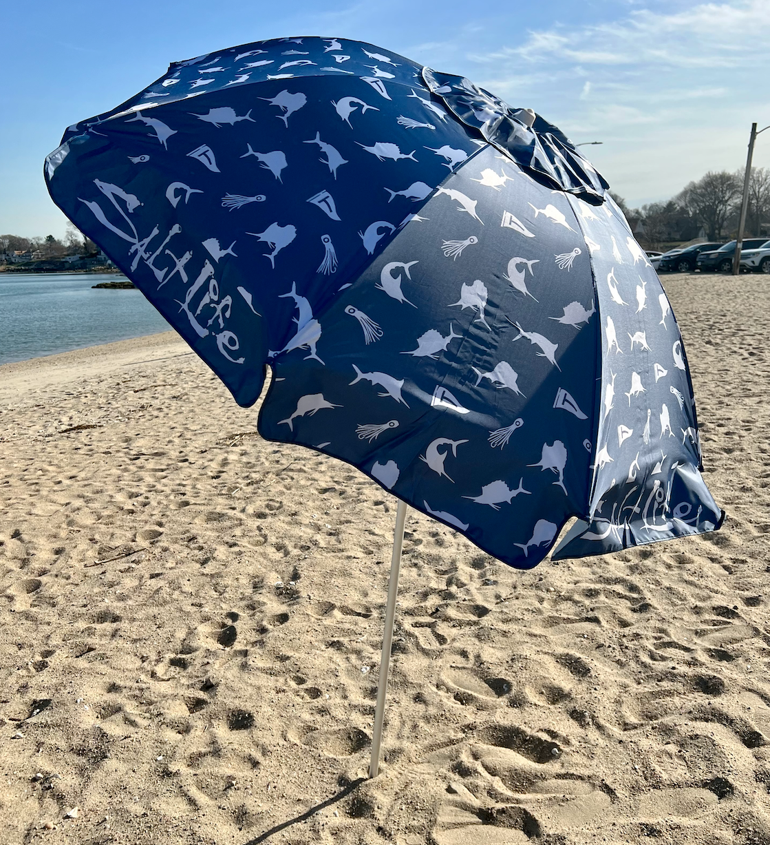 BuzzFeed writer's image of the blue umbrella in the sand at a beach