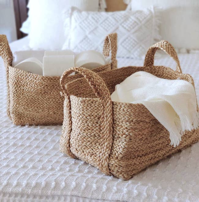 two baskets sitting on a bed