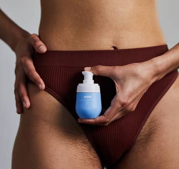 Person in underwear holding a skincare product for ingrown hair near groin 