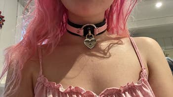 Reviewer wearing black and pink collar with padlock