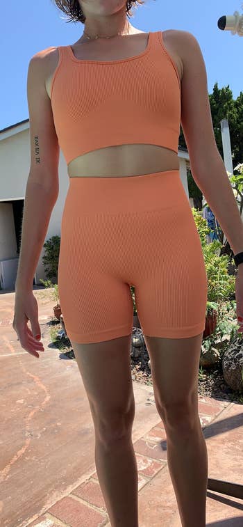 close up of another reviewer wearing the light orange set showing ribbed material 