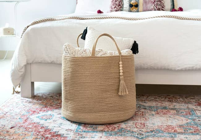 Woven basket with tassels in a bedroom, used for holding home items