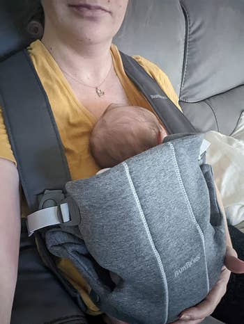 reviewer's photo of their baby in the dark gray carrier
