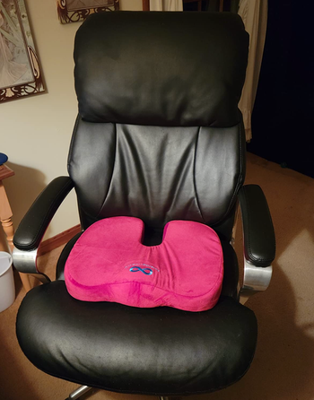 red memory foam seat cushion on a reviewer's desk chair
