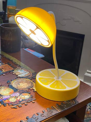 lemon style desk lamp on a table next to an unfinished puzzle