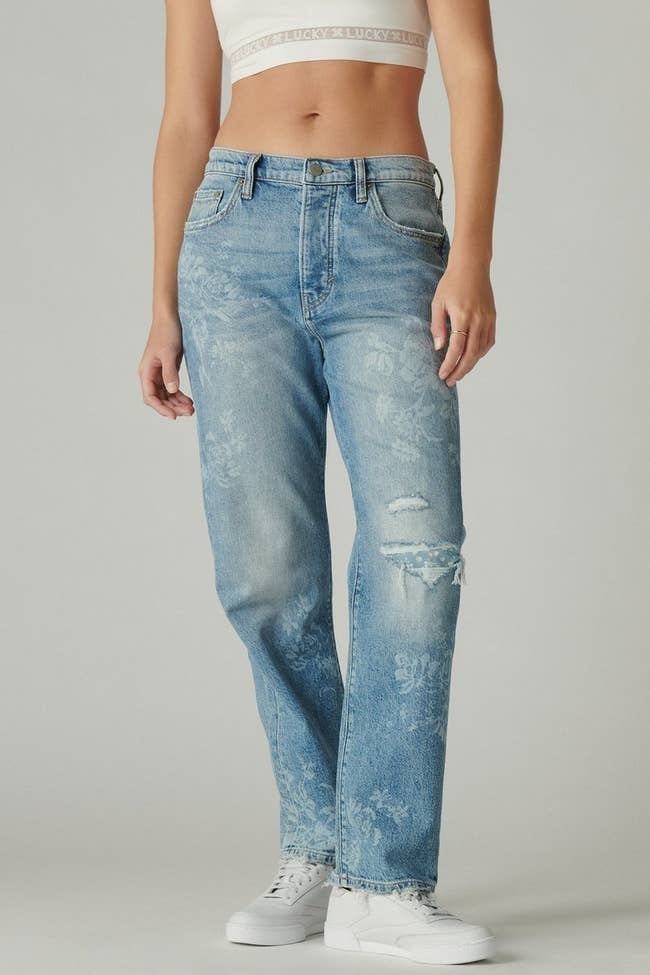 model wearing the blue jeans with subtle white flowers all over