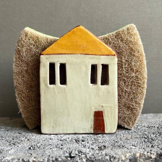 Ceramic location   sponge holder with minimalist plan  sits successful  beforehand   of a textured sponge. Perfect for room  decor and organization