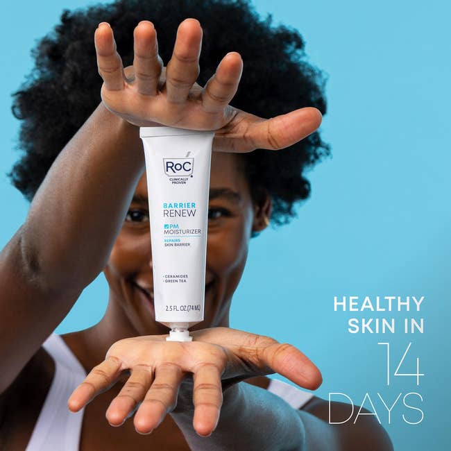 Person holding a conduit of RoC Barrier Renew moisturizer, smiling