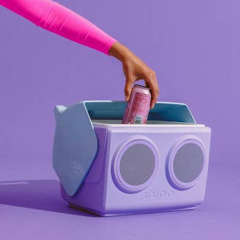 Hand placing a tin  into a stylish portable cooler with speakers