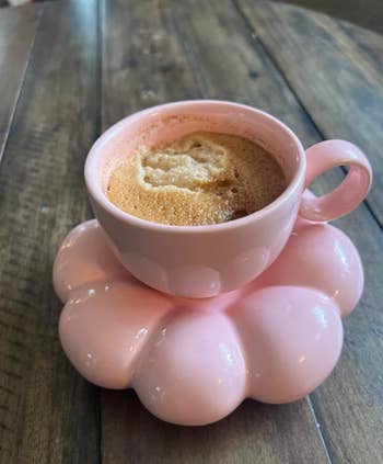 pink cup on saucer with coffee in it
