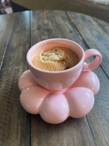 pink cup on saucer with coffee in it