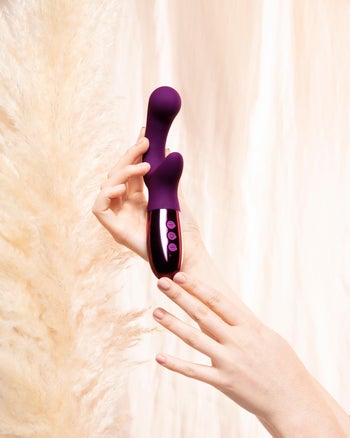 Model holding purple dual stimulation vibrator
