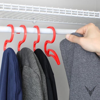 someone hanging up hoodies using hoodie hangers
