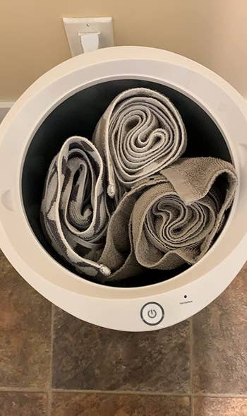 three towels rolled up inside the towel warmer