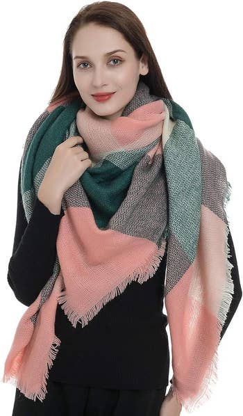 a model wearing the oversized scarf in pink, green, and grey color blocking