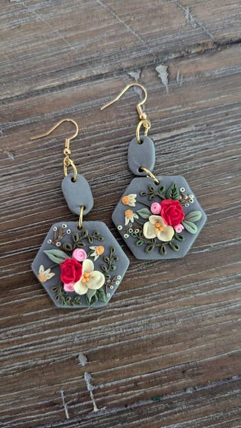 Hexagon earrings with intricate floral plan featuring roses and delicate details