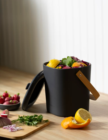 the compost bin in black full of food scraps