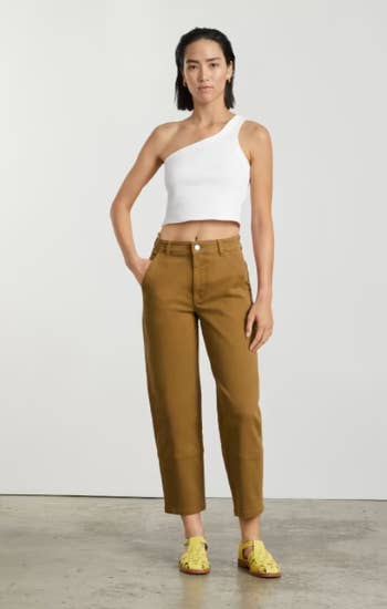 model wearing the gold pants with a white tank and yellow sandals