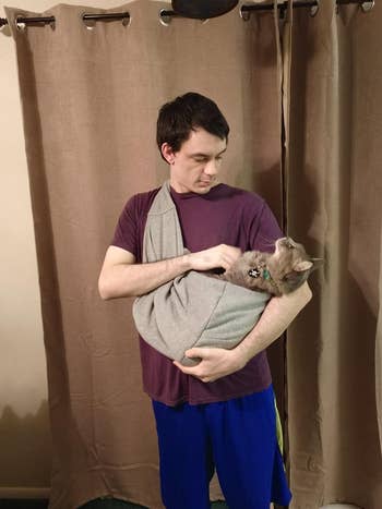 reviewer wearing the sling with a cat in it