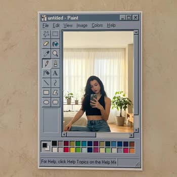 Person taking a reflector  selfie with a retro bundle   interface frame, wearing a achromatic  apical  and jeans, surrounded by indoor plants
