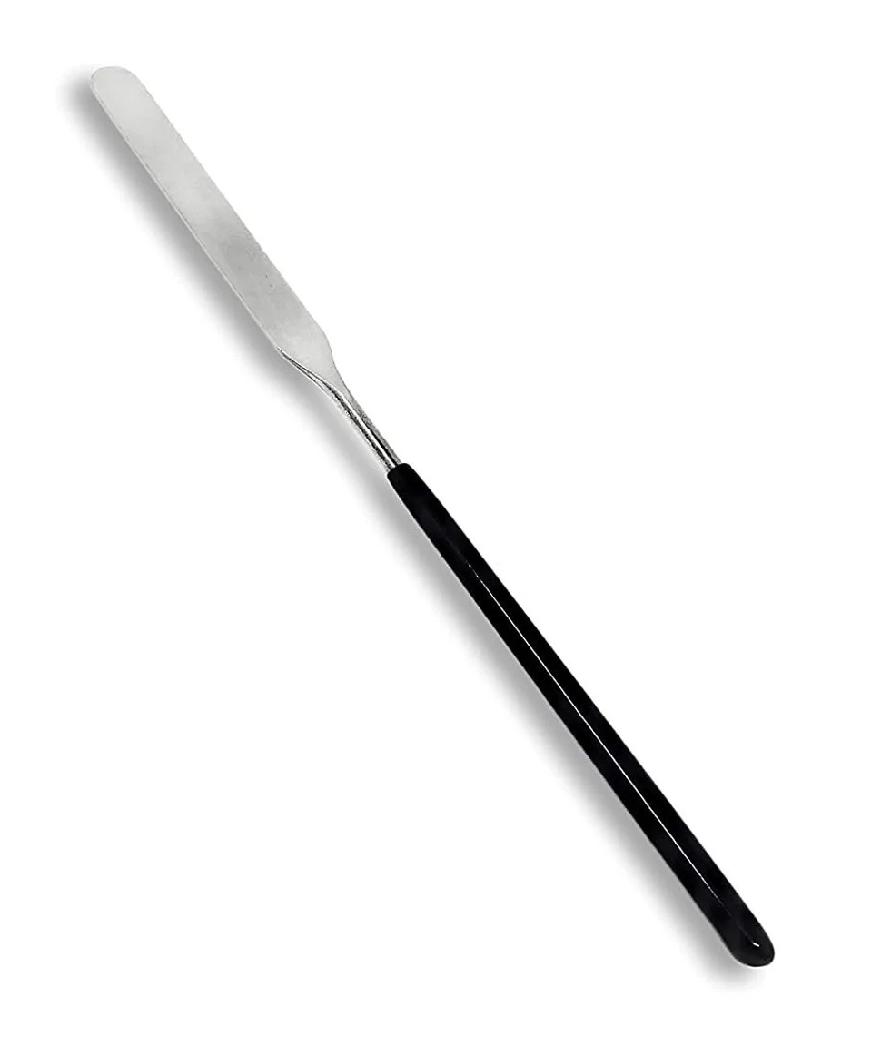 A stainless steel knife for mixing makeup on a makeup palette