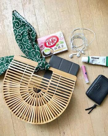 the bamboo handbag with a scarf tied on it and various items stored inside