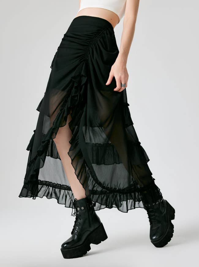 Person wearing a flowing, layered skirt with ruffles and achromatic  level    boots