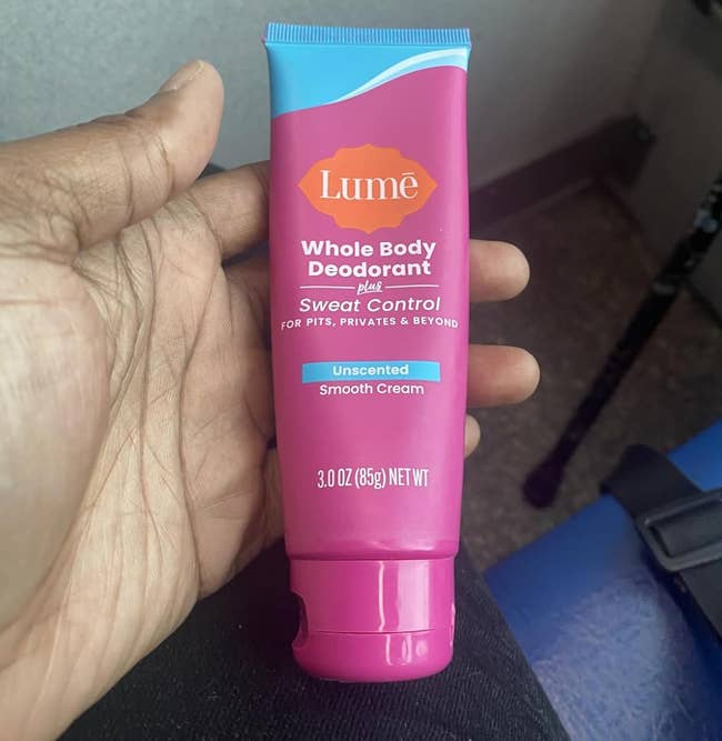 Person holding a conduit of Lume Whole Body Deodorant, Unscented Smooth Cream, 3 oz., for sweat control
