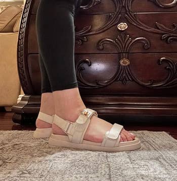 reviewer wearing the sandals with two straps across the top of the foot and one behind the ankle