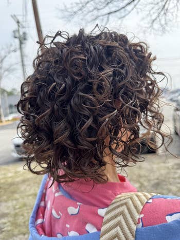 Person outdoors with curly, layered hair