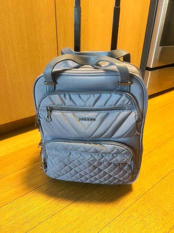 Quilted rolling luggage underseat container with zip pockets