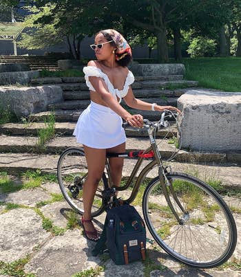 a reviewer wearing the skirt in white paired with a white crop top