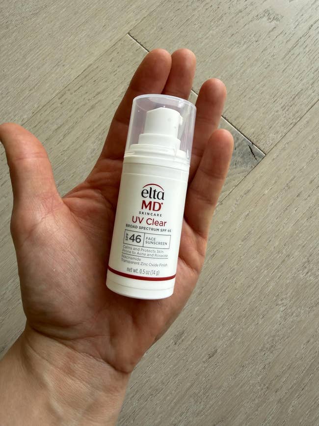 Hand holding a tiny vessel of Elta MD UV Clear SPF 46 sunscreen, designed for delicate skin