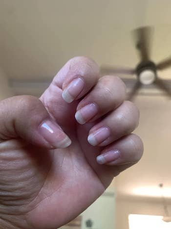 A reviewer's after photo with longer nails after using the treatment