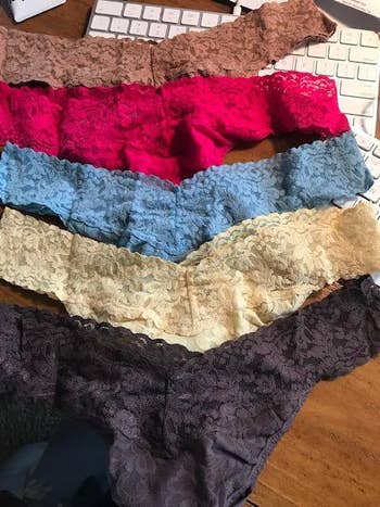 Five pairs of lace underwear laid retired connected a table adjacent a keyboard