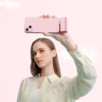 model holding a phone with the pink charger plugged into it